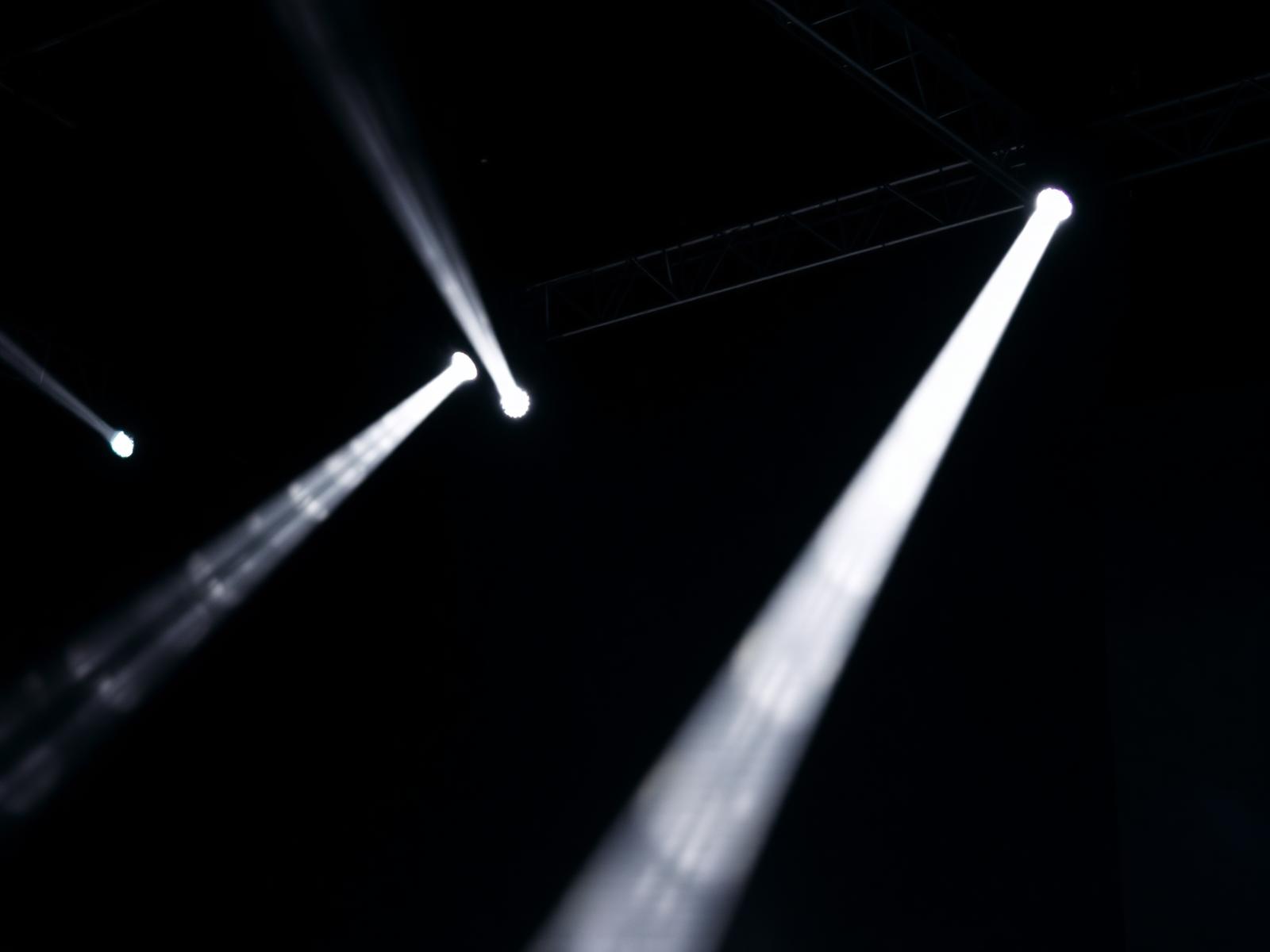 Stage lighting trusses with beams piercing fog